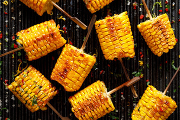 Grilled corn on the cob with butter and  salt  on the grill plate, top view