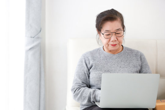 Asian Senior woman retirement using laptop computer in living room