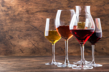 Wine set. Red, white and rose wine in assortment in wineglasses. Wine tasting, vintage wooden background, selective focus, copy space