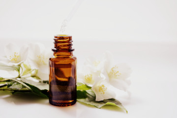 Jasmine essential oil in a glass bottle for hair and skin. Aromatherapy and Spa concept