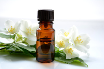Jasmine oil or essence in a glass bottle for hair and skin. Aromatherapy and Spa concept