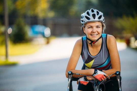 Image Of Young Woman In Helmet On Bike Ride On Summer Day