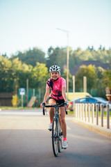 Fototapeta na wymiar Picture of young woman in helmet on bike ride on summer day