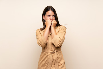 Young girl over isolated background nervous and scared putting hands to mouth