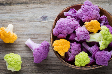 Rainbow of eco cauliflower on the wooden table.