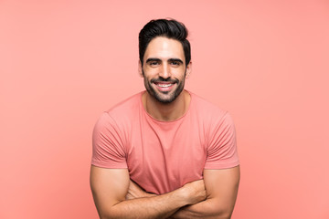 Handsome young man over isolated pink background laughing