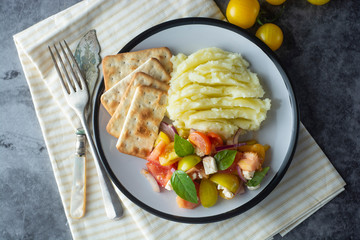 Tomatoes fresh salad and mushed potatoes in a plate. Healthy, summer food.