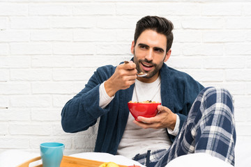 Man in bed with dressing gown and having breakfast