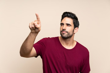 Handsome young man over isolated background touching on transparent screen