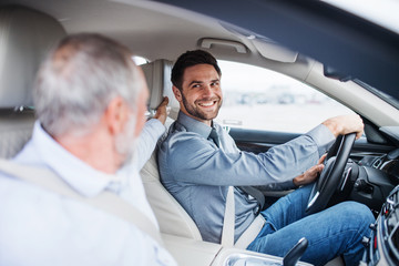 Father and son sitting in car, driving and talking.