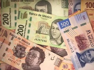 Mexican peso bills spread randomly over a flat surface
