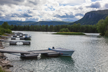 Boats on an anchor in the scenic delta of two rivers in Kvikkjokk in Swedish Lapland.