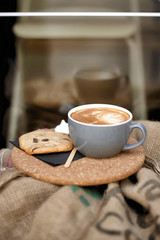 Coffee with froth and coffee beans in a sack
