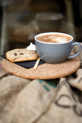 Coffee with froth and coffee beans in a sack