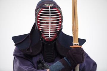 Portrait of man kendo fighter with shinai bamboo sword . Shot in studio. Isolated with clipping...