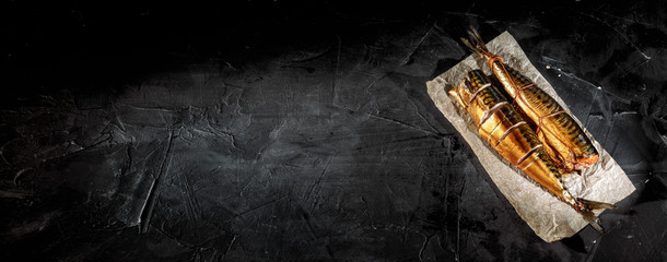 Delicious smoked fish on dark background.Top view with copy space