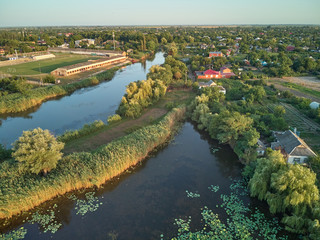 Fototapeta na wymiar Aerial view of a village with a small river and a pond with a growing lotus