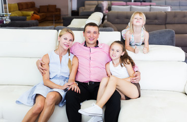 Family posing near new sofa