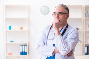 Old male doctor working in the clinic