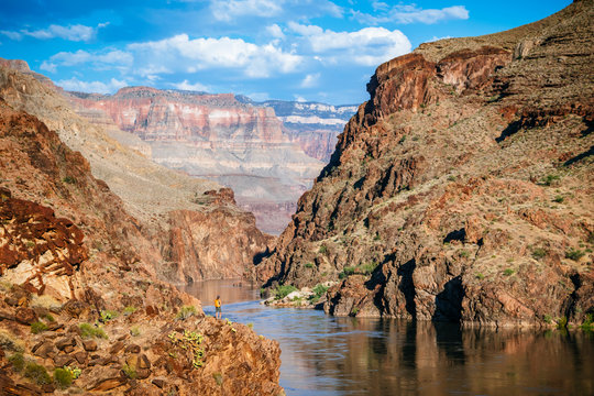 A woman stands above the Colorado River at Mile 136 of a rafting trip, Grand Canyon National Park, Arizona, USA
