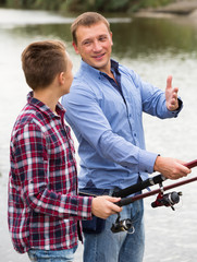 Obraz premium Father and son fishing on river