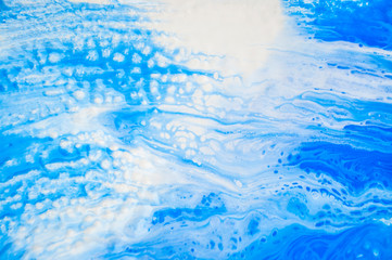 Abstract colorful painting background made in fluid art technique. Trendy pattern in blue and white colors.