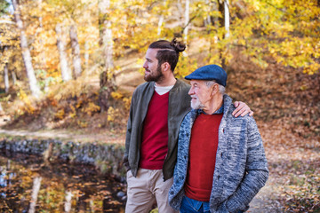 Senior father and his son walking in nature, talking.