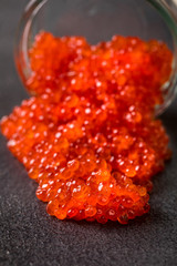 Salmon  Red Caviar in a white plate on a dark background. Healthy Food Concept. Snack.Seafood.