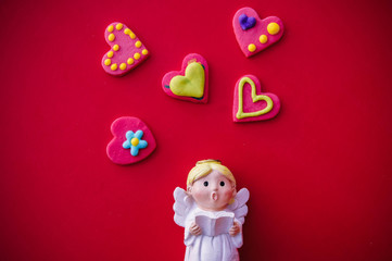 Cupid doll and heart-shaped on red background