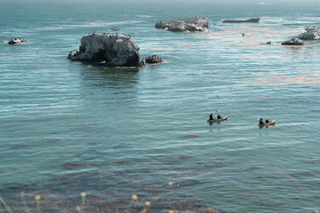 Pismo Beach, California/USA - July, 28, 2019. Cliffs in the Ocean. Pismo Beach Cliffs and Flock of Birds. Kayaking around the Rocks. California Coastline
