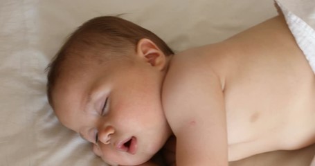 View from above of the newborn baby, close up shot. A cute little baby sleeping