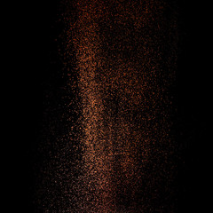 Cocoa powder sifting isolated on black background. Chocolate dust on black background