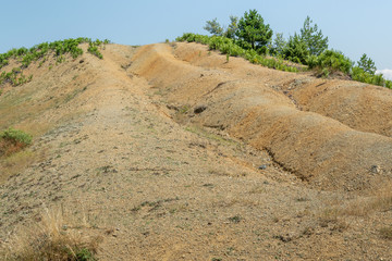 Albanian nature landscape. Sandy hills with rainwater sign on the ground.