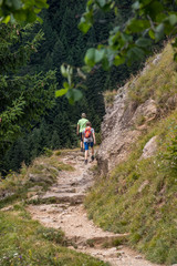 Obraz premium Steiniger Wanderweg in den Alpen mit Frau und Mann