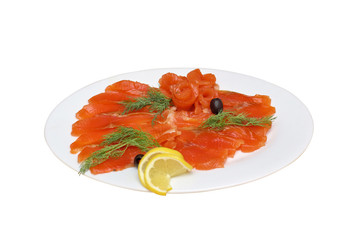 Sliced red fish with olives and lemon on a white plate, isolated close-up