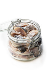 Sliced salted herring in glass jar isolated on white