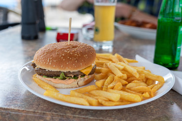 Burger and french fries on the table. Delicious food fast food. American food in a cafe