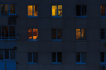 Lighted windows and balconies of an old night residential building