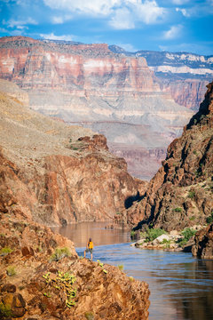 A woman stands above the Colorado River at Mile 136 of a rafting trip, Grand Canyon National Park, Arizona, USA