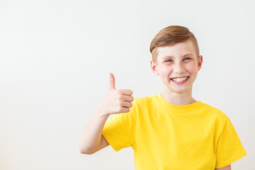 Young fresh teenager is posing with a thumb up sign