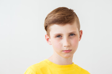 Serious teen boy with big glasses on white background.