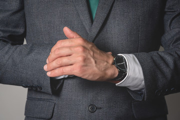 Businessman is wearing a wrist watch close up.