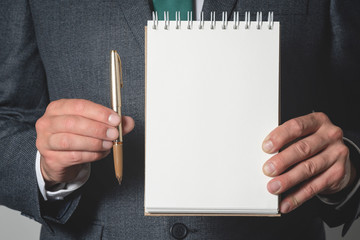 Business to do list mockup. Business plan. Businessman holding a blank page notepad and a pen.