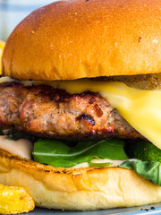 Hamburger background. Macro Fresh vegetables and grilled meat in bread roll