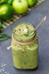 Vegetable green smoothie anh whole ingredients on a dark background
