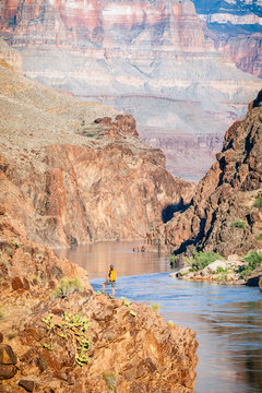 A woman stands above the Colorado River at Mile 136 of a rafting trip, Grand Canyon National Park, Arizona, USA