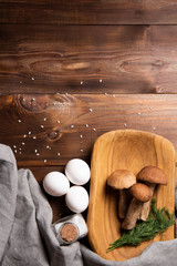 wooden tray with porcini mushrooms on a wooden table. Ingredients before cooking. Copy space