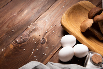wooden tray with porcini mushrooms on a wooden table. Ingredients before cooking. Copy space
