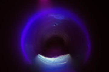 Blur neon purple arc glow. Colored lens flare. Dark abstract background. Tunnel effect.