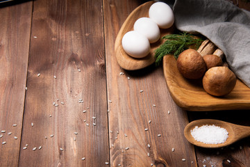 wooden tray with porcini mushrooms on a wooden table. Ingredients before cooking. Copy space